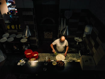 High angle on man cooking pizza