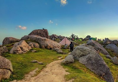 People and tents on mountain against sky