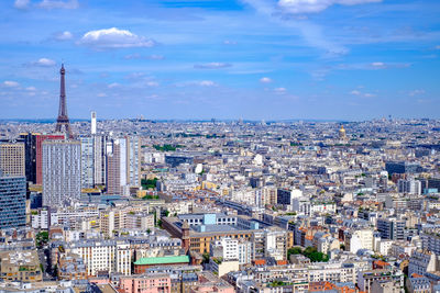 Aerial view of cityscape against cloudy sky