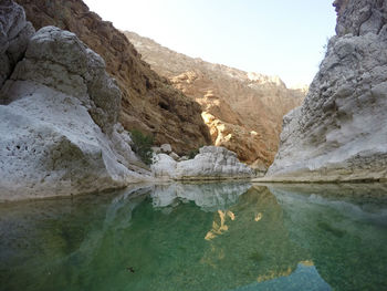 Scenic view of lake by mountain against sky