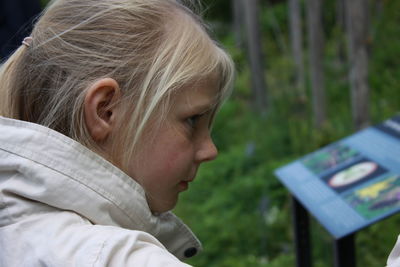 Side view of thoughtful girl looking away in forest