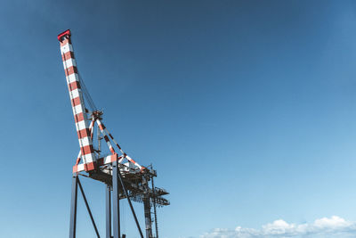 Low angle view of crane against blue sky