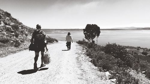 Rear view of man and woman walking on road