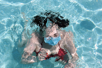 High angle view of woman wearing mask in swimming pool