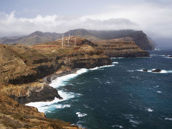 High angle view of rocky coastal feature against sky