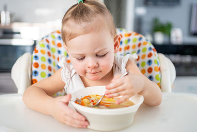 Portrait of boy eating food at home