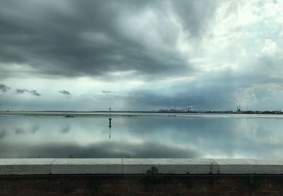 Scenic view of sea against storm clouds