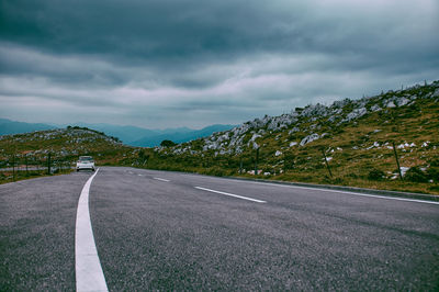 Road by mountain against sky