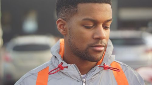 Close-up of young man looking away in city