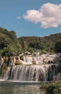 Scenic view of waterfall against sky