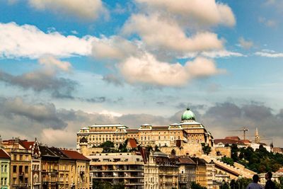 View of buildings in city against cloudy sky