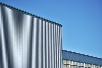 Low angle view of modern building against clear blue sky