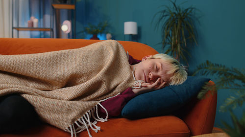 Portrait of woman sitting on sofa at home