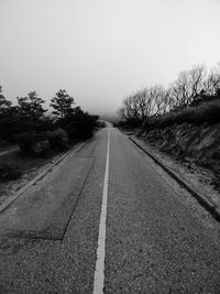 Road amidst trees against clear sky