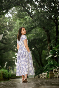 Full length of a girl standing against trees