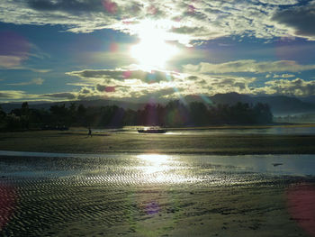 Scenic view of wet beach against sky