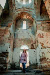 Full length of woman standing against building