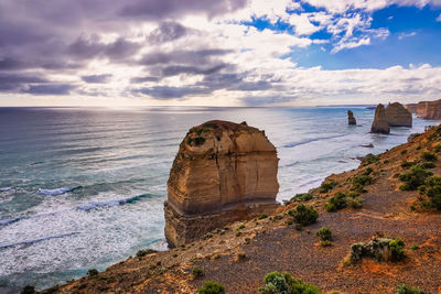 Rock formation on sea shore against sky