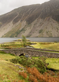 Scenic view of river by mountains against sky