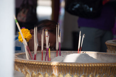 Close-up of burning incense in vase at temple