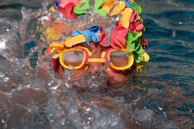 Close-up of man wearing swimming goggles while swimming in sea