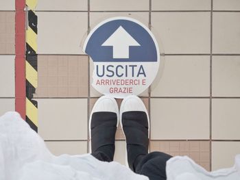 Low section of man standing on tiled floor