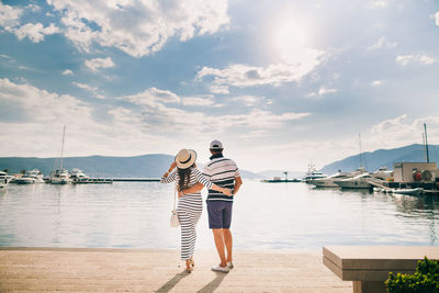 Rear view of couple standing on promenade against sky