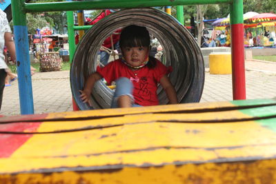 Portrait of smiling young woman sitting on slide