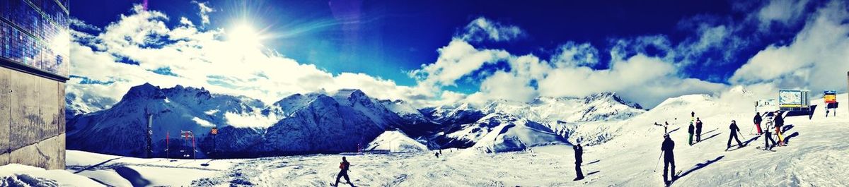 Scenic view of snow covered mountains against blue sky