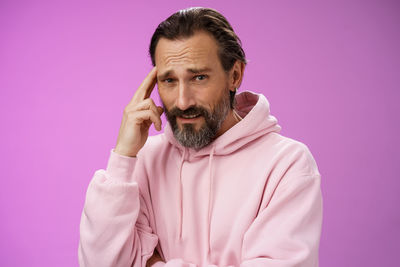 Thoughtful man against purple background