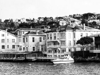 Buildings by river against clear sky