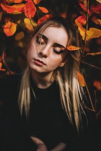 Close-up of young woman with leaves