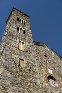 Low angle view of old building against clear blue sky