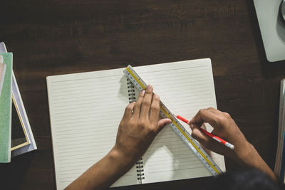 Midsection of woman reading book on table