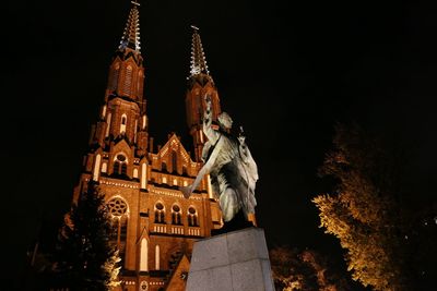 Low angle view of illuminated city against sky at night