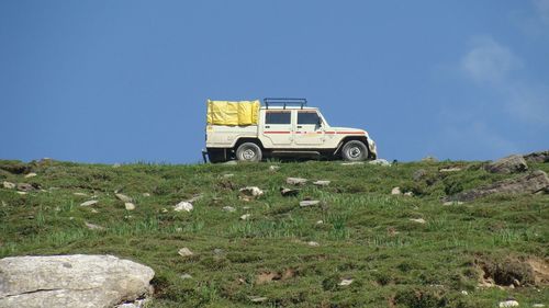 Pick-up truck parked on grassy field against sky