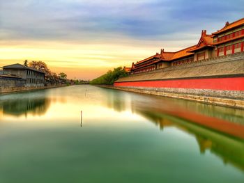 Scenic view of river by forbidden city against sky