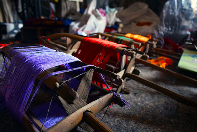 Multi colored strings on wooden equipment in factory