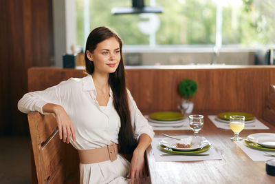 Portrait of young woman sitting on table