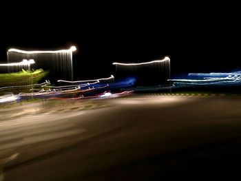 Illuminated lights on beach against sky at night