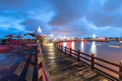 Pier on sea against cloudy sky