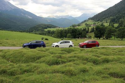 Car on field by mountain against sky