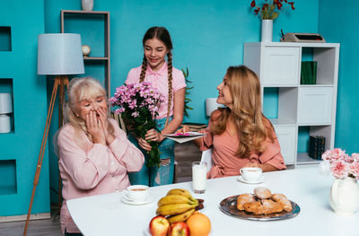 Cute girl giving flowers to grandmother