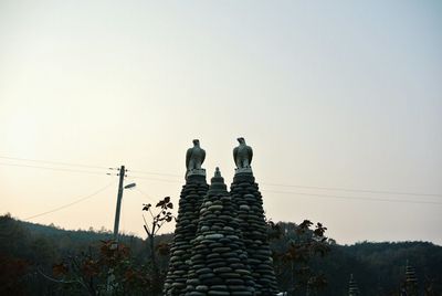 Low angle view of stack of tree against clear sky