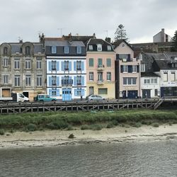 Residential buildings by river against sky