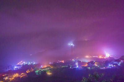 Illuminated city against sky at night