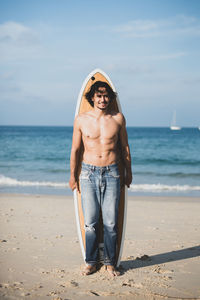Portrait of shirtless man standing on beach