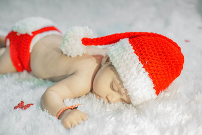 Close-up of baby girl lying on bed