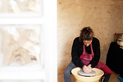 Ceramist artist female working in her atelier with the pottery wheel