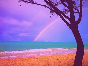 Scenic view of rainbow over sea against sky